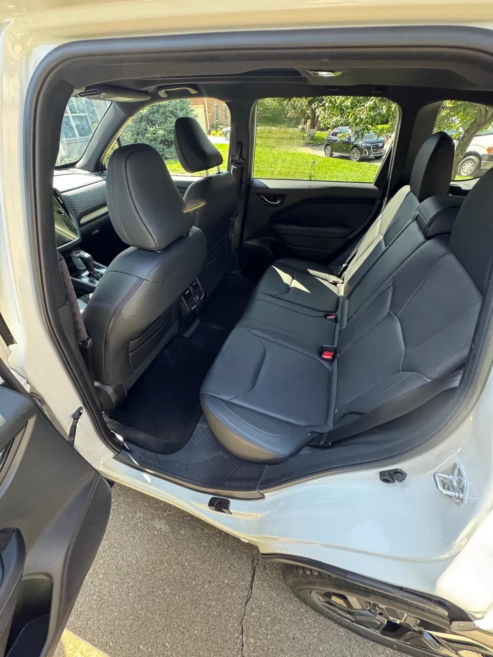 Cleaned rear seats and carpet of a white Subaru Forester after an interior detail
