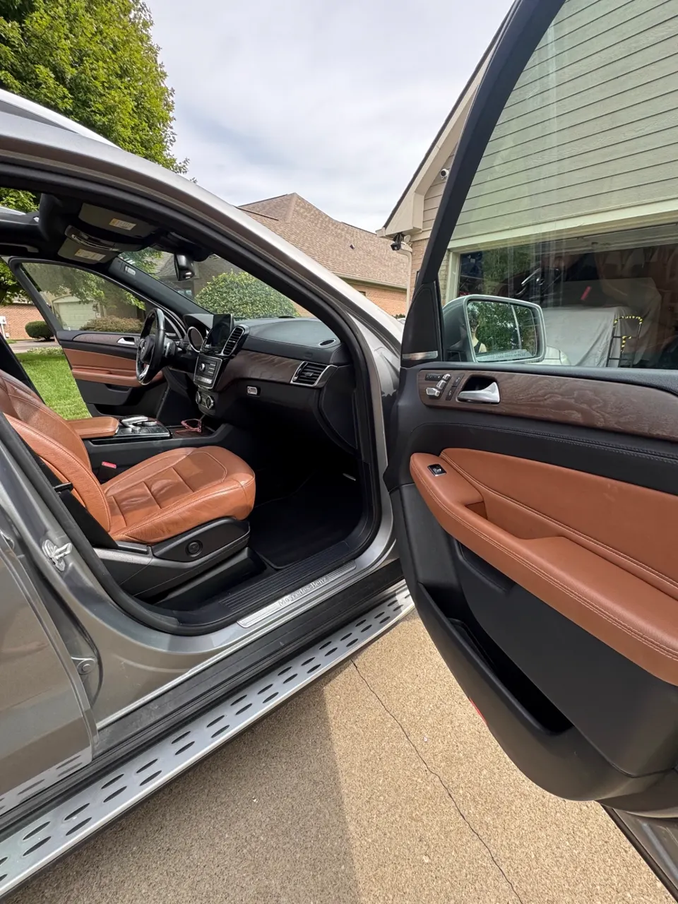 Open passenger door of a Mercedes-Benz GLE showing detailed leather door card and clean interior