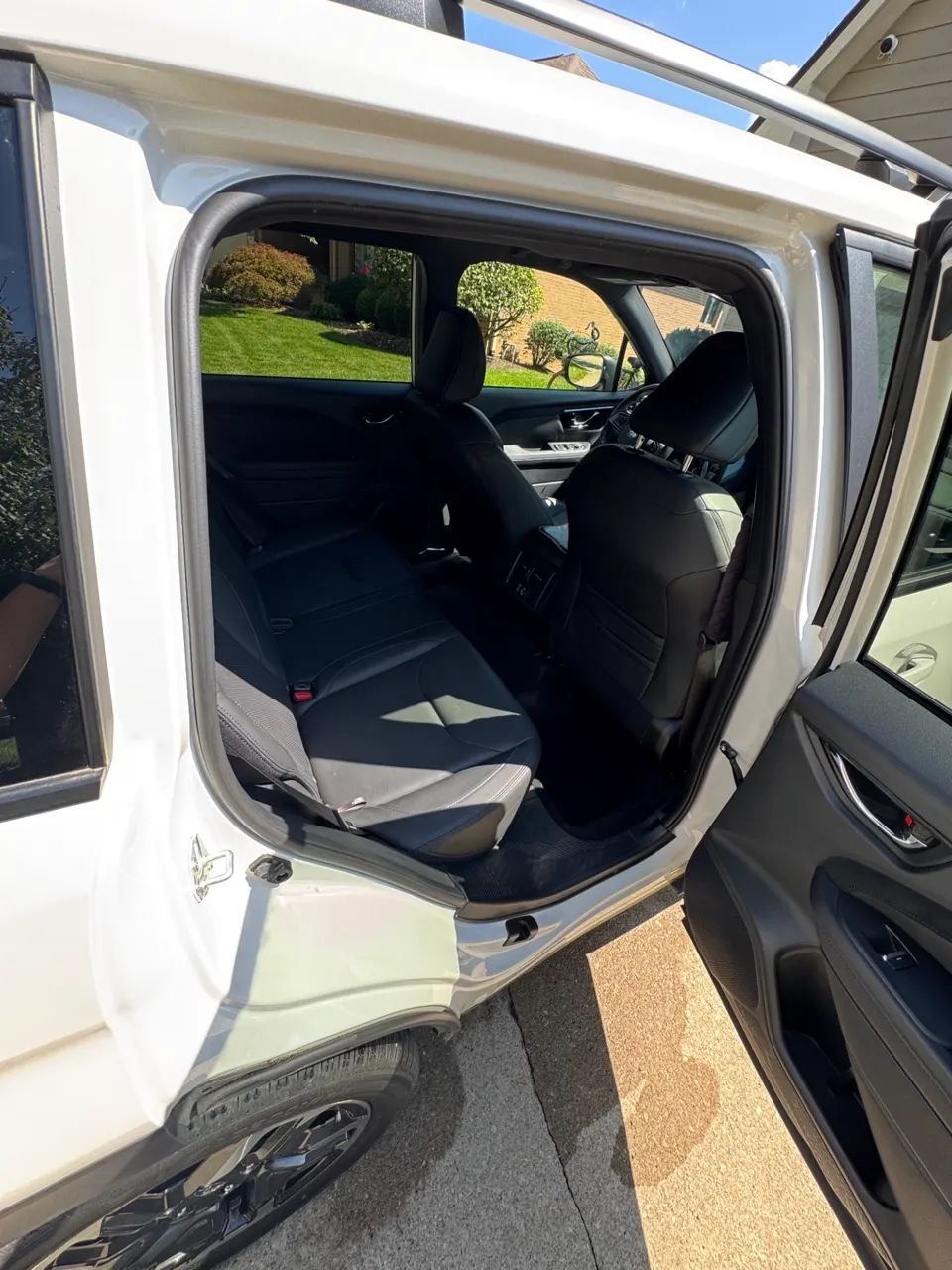 Rear passenger door open showing spotless seats, panels and door sills