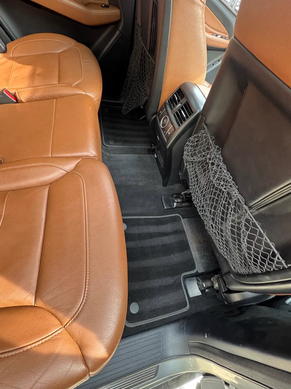 Close view of conditioned cognac leather seats and clean rear floor mats in a Mercedes-Benz GLE