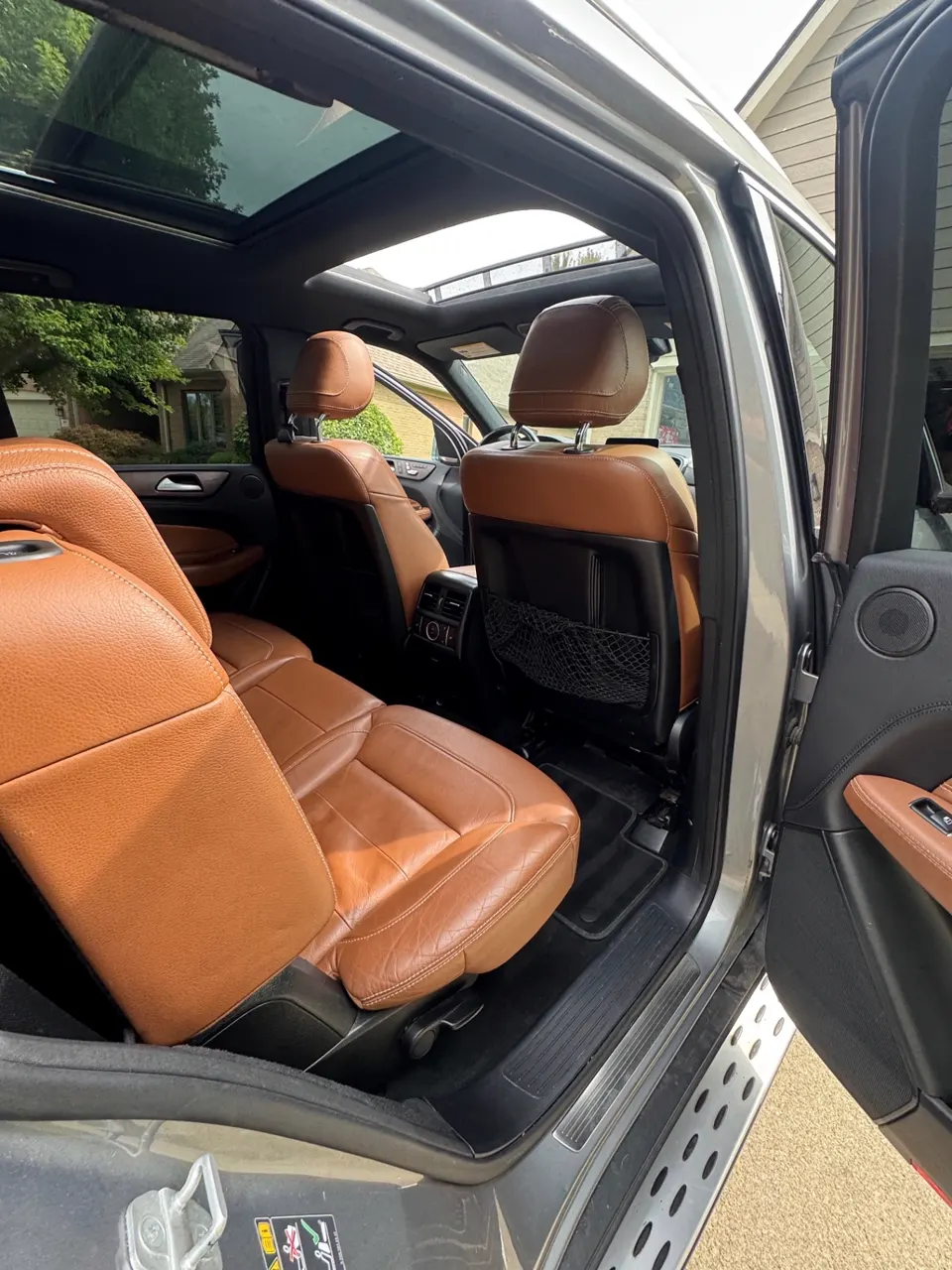 Rear passenger side of a detailed Mercedes-Benz GLE with panoramic roof and clean leather seating