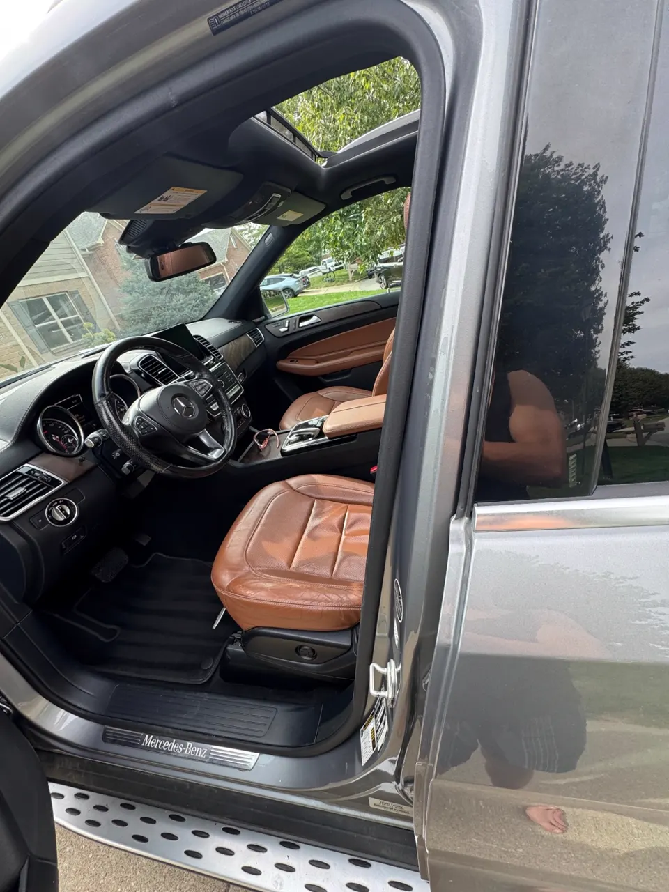 Driver's side of a detailed Mercedes-Benz GLE, cognac leather seats and black carpet spotless